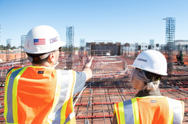 Two site engineers in high-visibility clothing inspecting a construction site