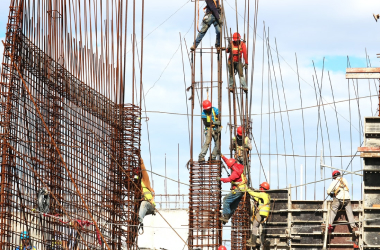 Steel reinforcement cages being erected for concrete columns on a construction site