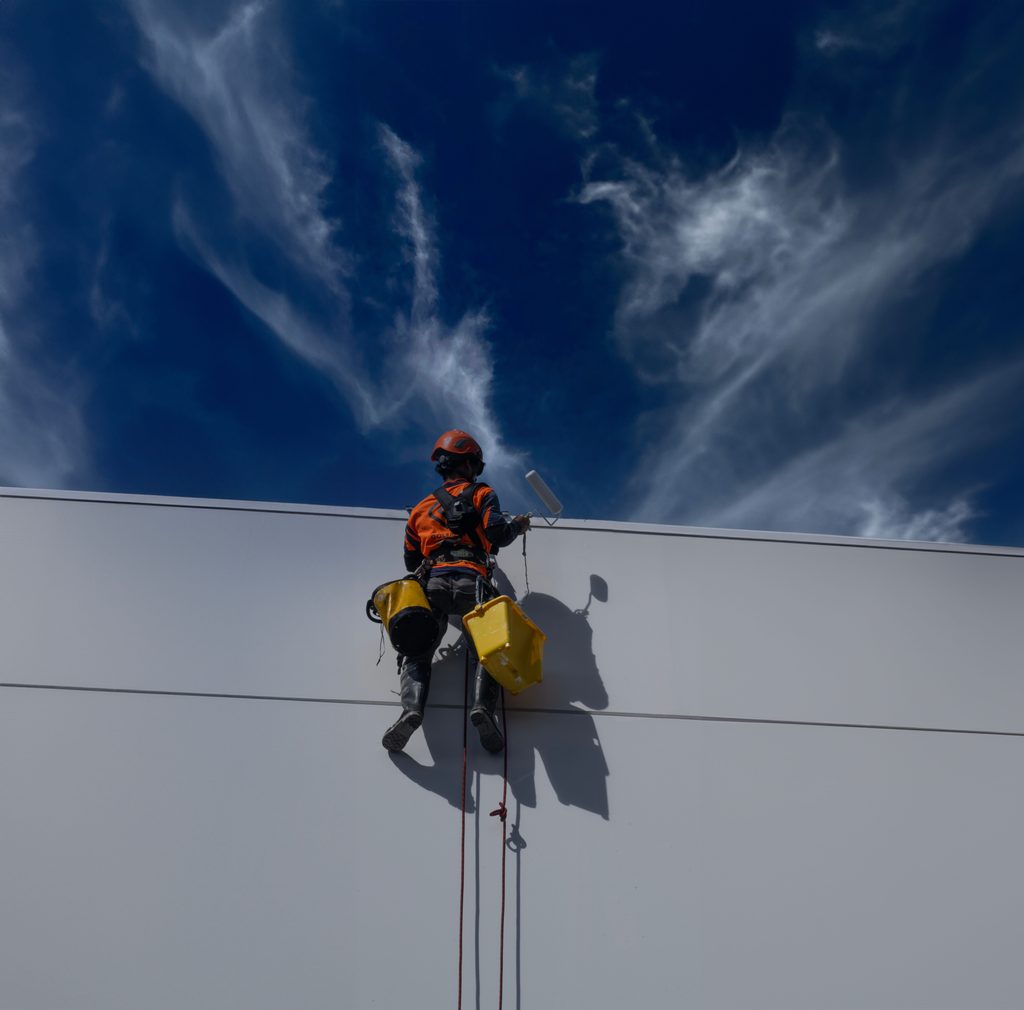 Rope access technicians working on a high-rise commercial building façade