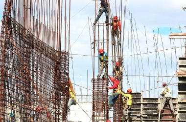 Steel reinforcement cages being erected for concrete columns on a construction site